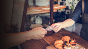 Person paying with card at a bakery.